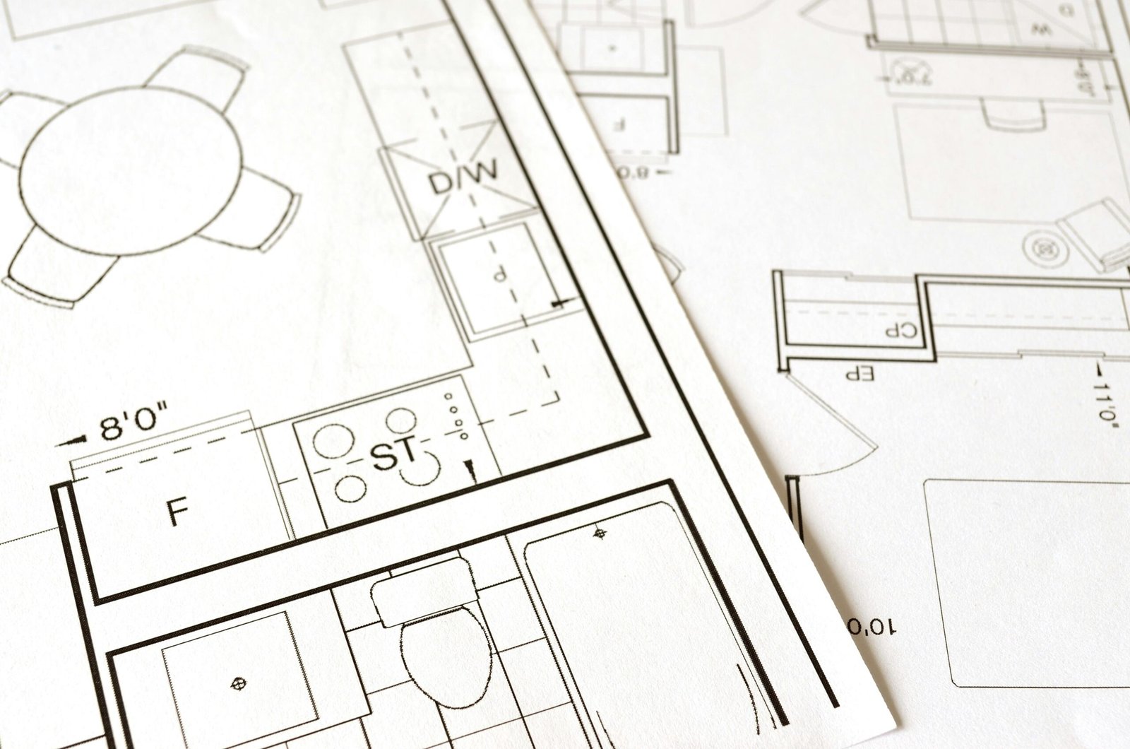 Close-up view of an architectural floor plan on paper showcasing detailed room layouts and measurements.